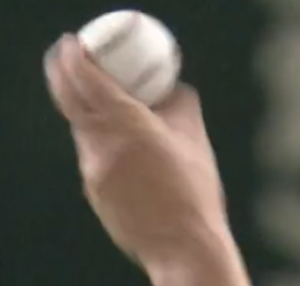 A close-up of how he throws the slider, with his first 2 fingers touching both sets of seams.