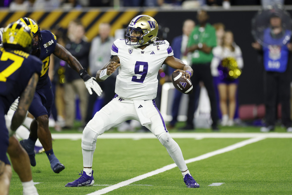 Michael Penix Jr., in white shirt with purple number 9 and a gold helmet, prepares to make a left-handed throw