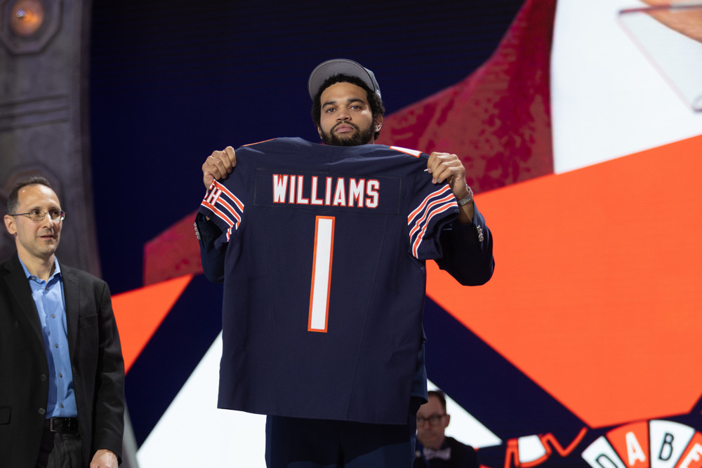 Caleb Williams poses with a No. 1 jersey after being selected in the NFL Draft.