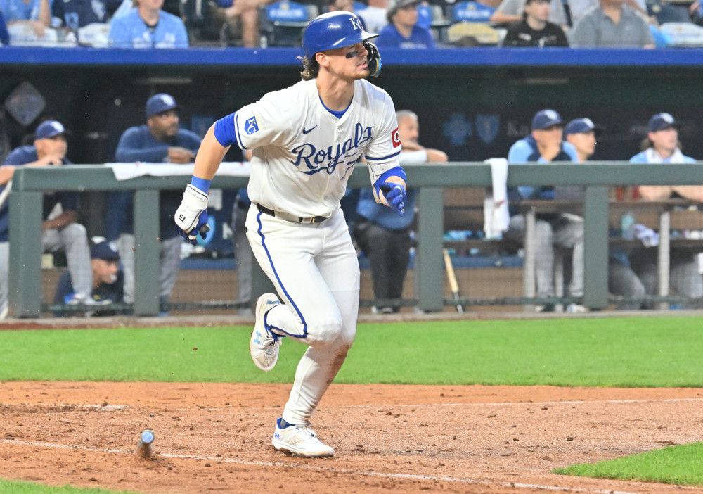 Bobby Witt Jr. starts to run to first base after hitting the ball.