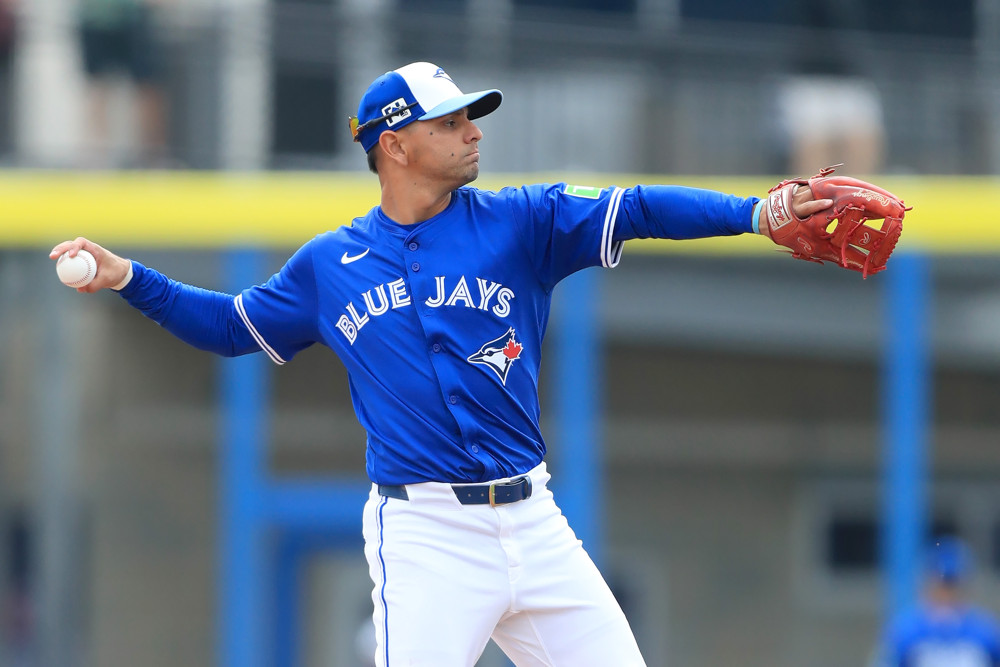 Andres Gimenez warms up during spring training and prepares to make a throw to first base.