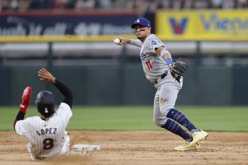 Miguel Rojas brings his right arm back as he prepares to throw to first base to complete a double play.