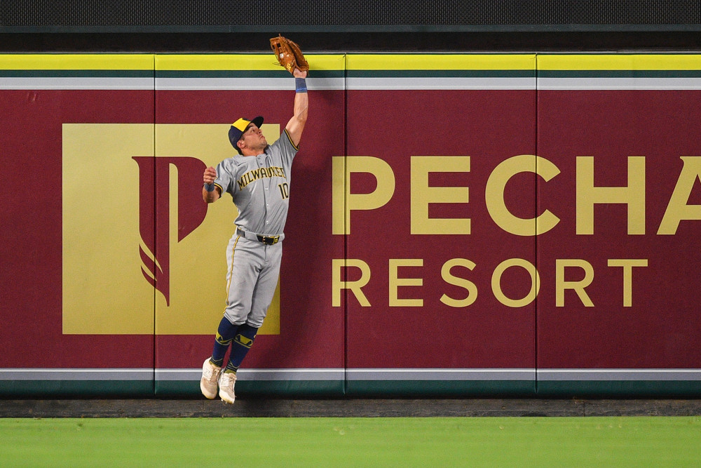 Sal Frelick jumps at the fence to make a catch for the Brewers.