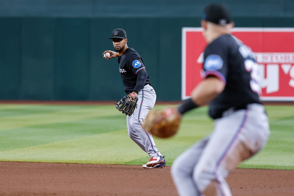 Otto Lopez prepares to make a throw to first base, as he holds the ball back in his right hand.