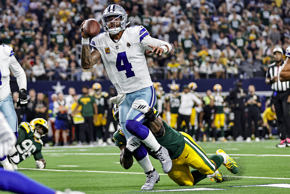 Micah Parsons of the Packers tackles Dak Prescott of the Cowboys from behind.