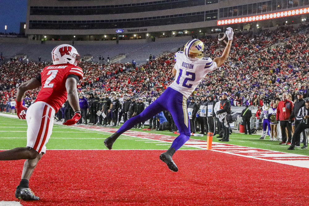 David Boston, wearing a white #12 jersey and blue pants stretches out to make a catch in the end zone.
