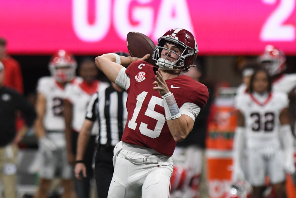 Ty Simpson, wearing a rd Alabama #15, brings his arm back, football in hand, to make a throw.